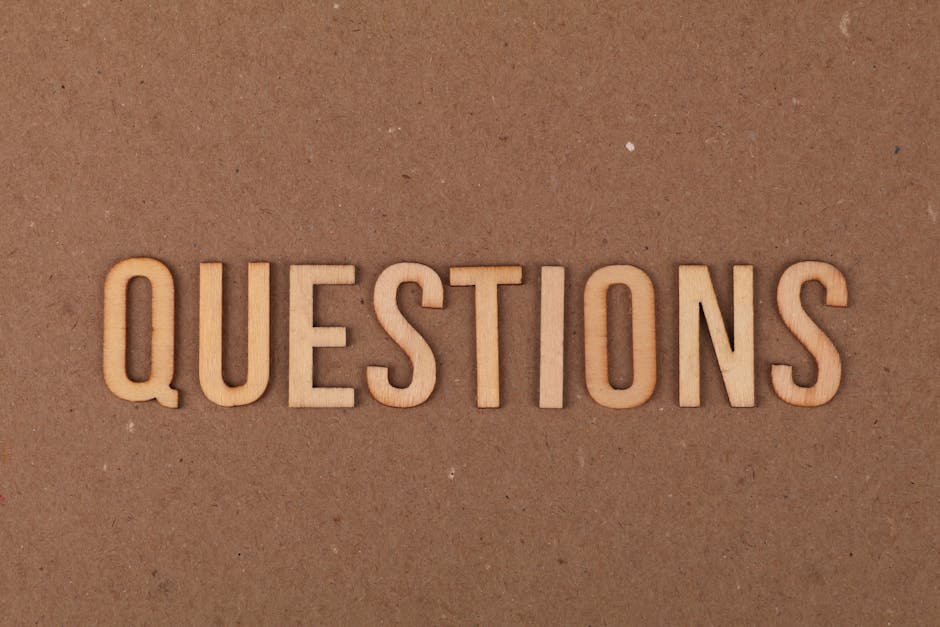 Wooden letters spelling the word "QUESTIONS" on a cardboard background, providing a neutral copyspace.