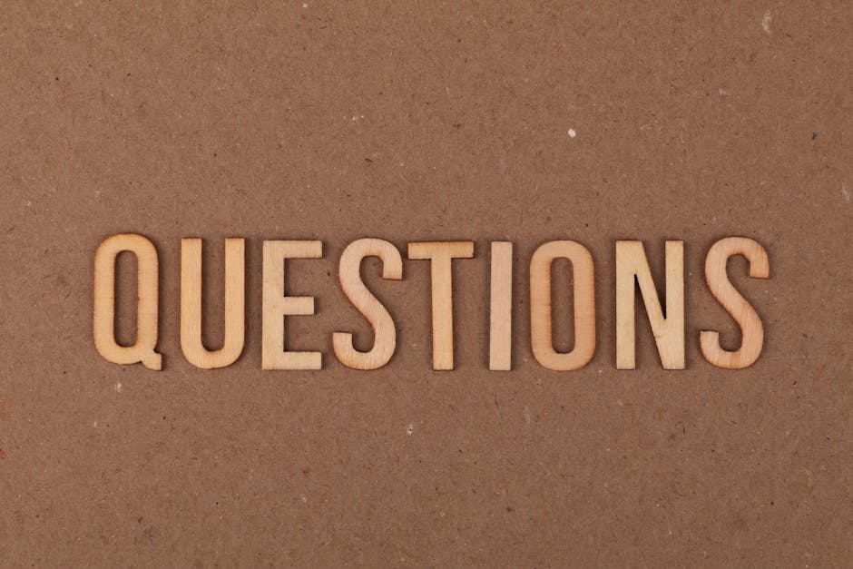 Wooden letters spelling the word "QUESTIONS" on a cardboard background, providing a neutral copyspace.