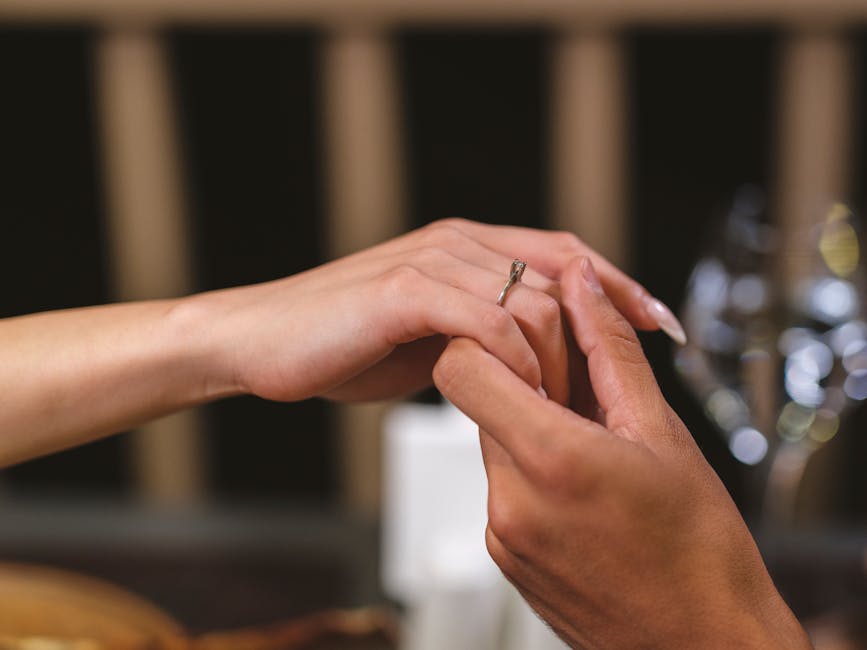 Close-up of a romantic marriage proposal with a diamond ring on elegant hands.