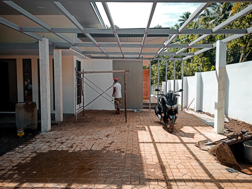 A partially constructed building with scaffolding and parked motor scooter on a sunny day.