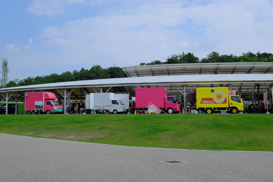 Colorful food trucks lined up in Ghibli Park, Nagoya, offering diverse culinary delights.