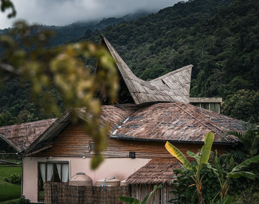 A picturesque view of a traditional Thai house nestled in lush mountains, capturing nature's serene beauty.