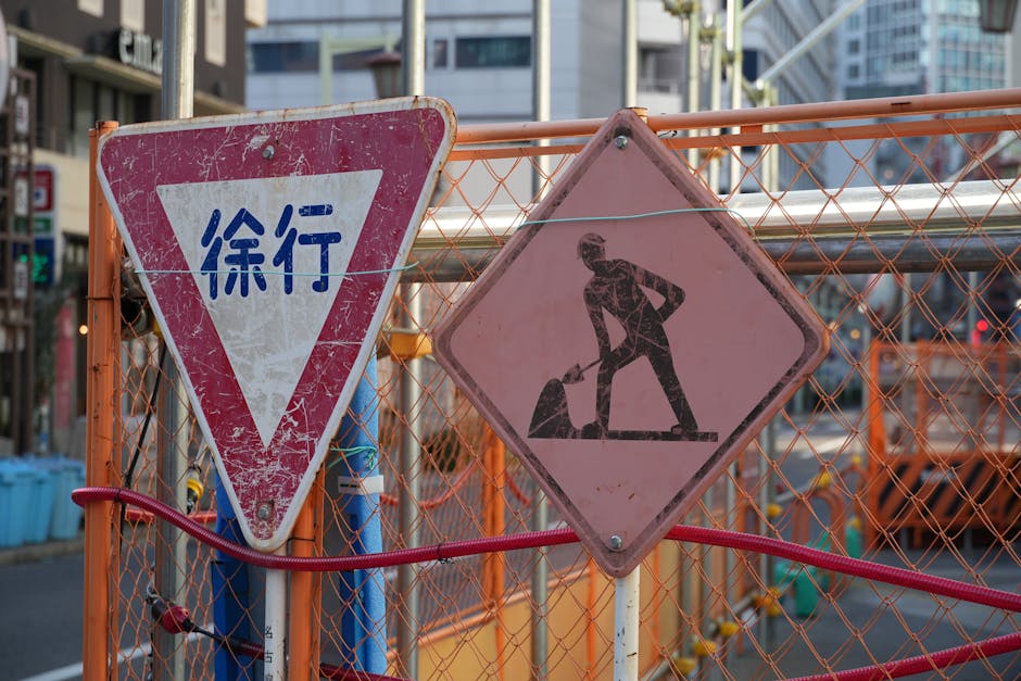 A construction site in a city with Japanese warning and roadwork signs.