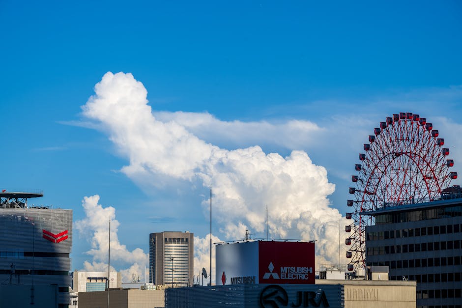 Vibrant urban skyline featuring towering buildings and a ferris wheel under a striking cloud formation.