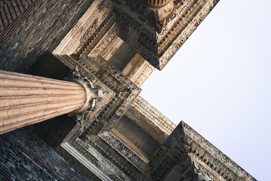 A close-up angular perspective of ornately carved ancient architectural columns with intricate detailing.