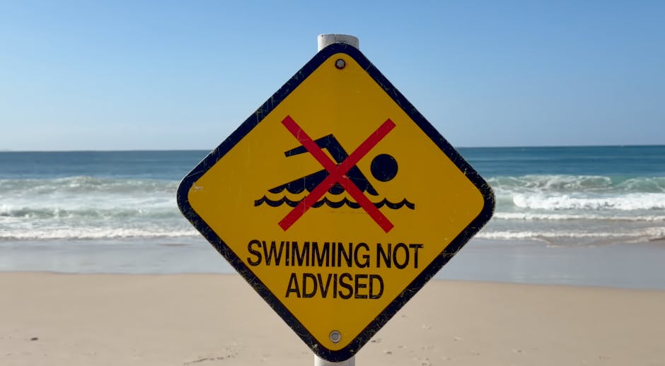 Warning sign on Byron Bay beach advising against swimming due to safety concerns.