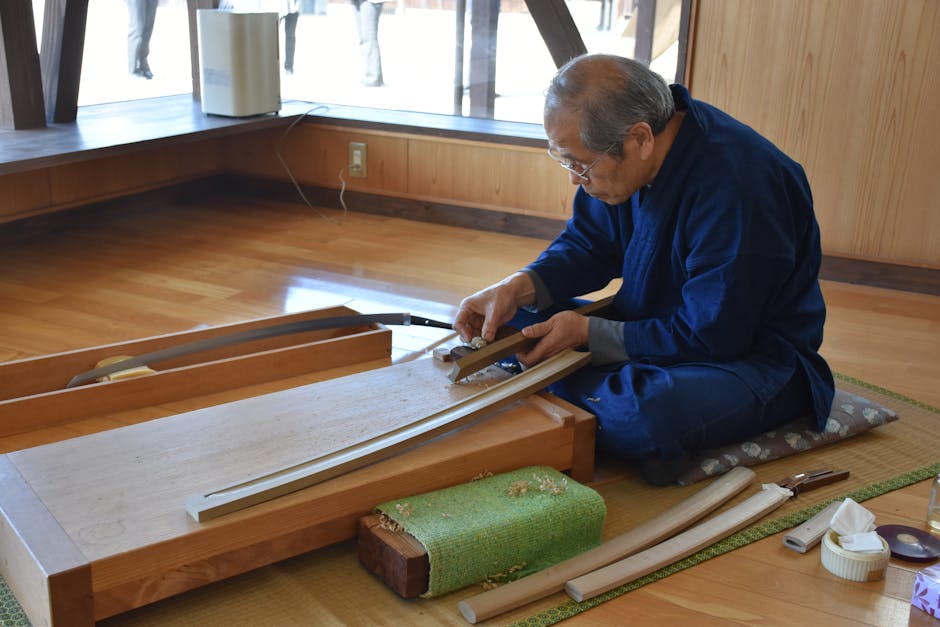 An experienced craftsman skillfully shaping a traditional Japanese sword indoors.