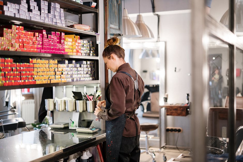 Hairdresser organizing hair color products in a modern salon.