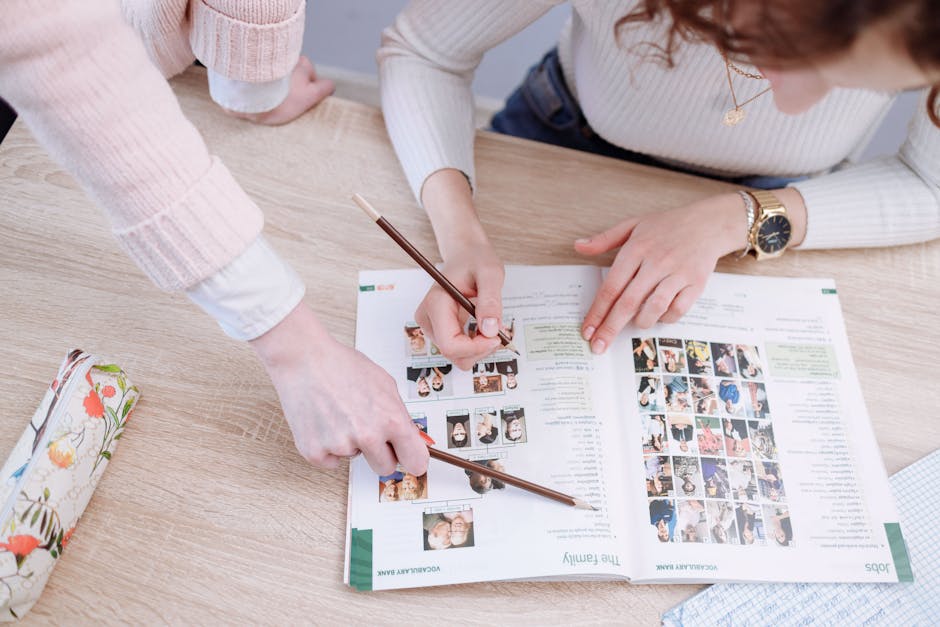 Students working together on an assignment, pointing at pages in a textbook.