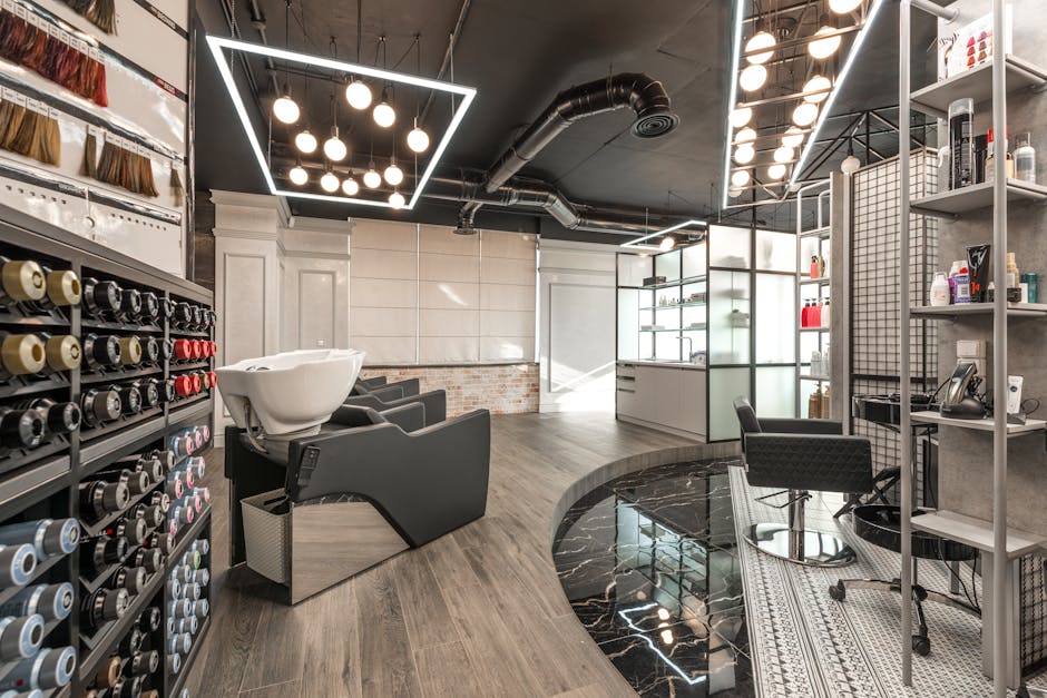 Black backwash chair with white sink placed in modern stylish beauty salon with various cosmetology products and bright glowing lamps