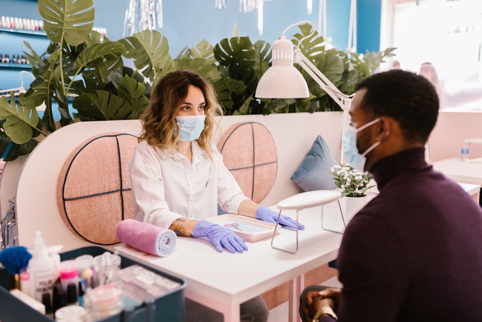 A man receiving a manicure in a stylish nail salon with safety measures.