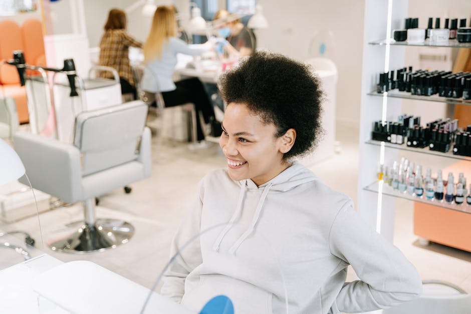 Happy woman with curly hair enjoying a relaxing time in a modern nail salon.