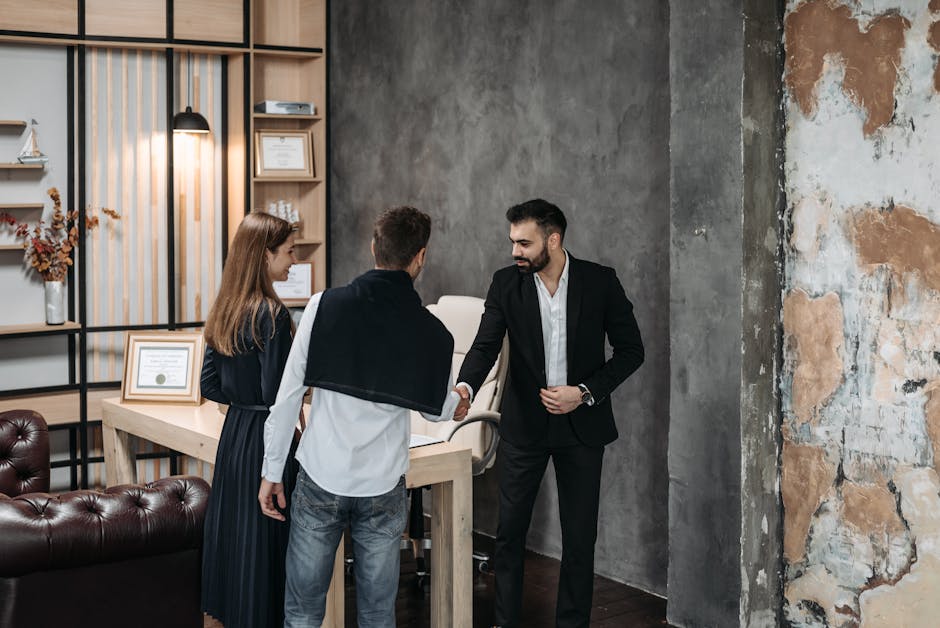 Business professionals discussing in a stylish, modern office setting with a handshake agreement.