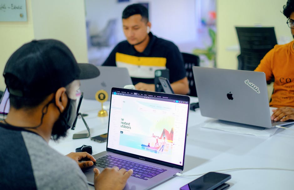 Business colleagues collaborating in an office setting with laptops and electronics.