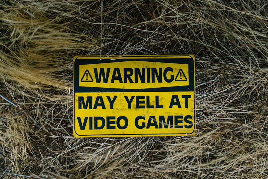 A funny yellow warning sign on grass reading 'Warning May Yell at Video Games'.
