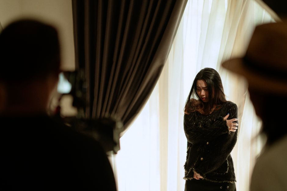 A woman actor performing a scene indoors, captured with dramatic lighting and intense emotion.