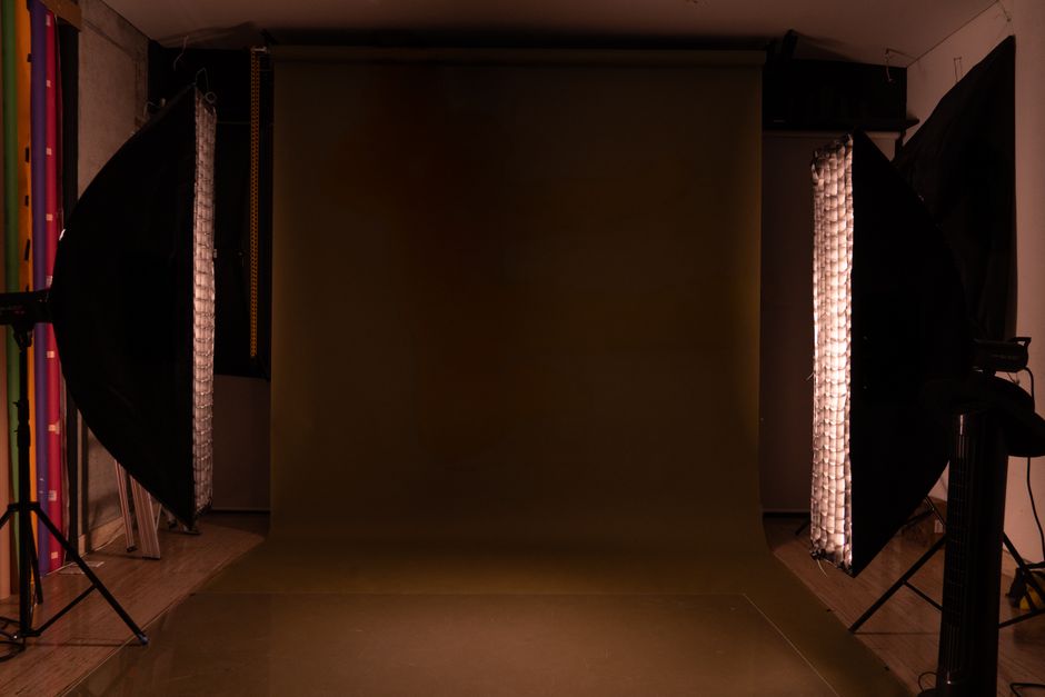 A sleek and modern photography studio setup featuring a mocha backdrop and professional lighting equipment.