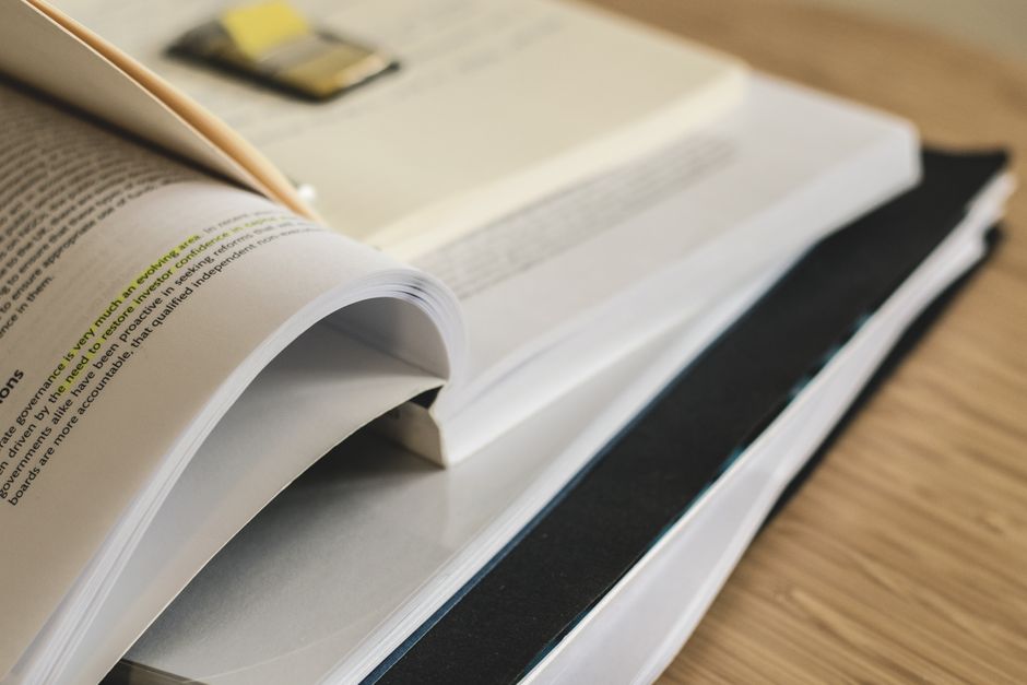 A pile of open books on a table, ideal for study and research themes.