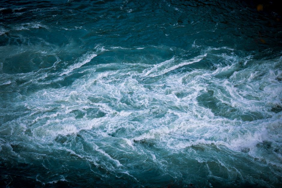 Dynamic whirlpool in vivid turquoise water creating a dramatic natural scene.