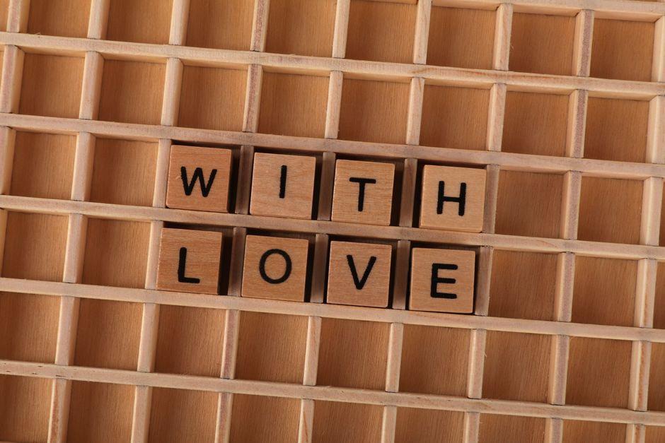 Wooden blocks spelling 'With Love' arranged on a grid, ideal for romantic themes.
