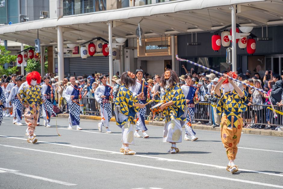 Colorful performers in traditional attire at a Kyoto festival parade.