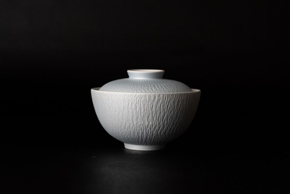 Smooth porcelain bowl showcased on a black backdrop, highlighting its Japanese design elegance.