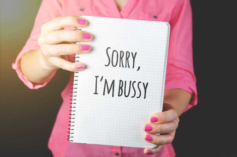 Woman holding a notebook with a handwritten message featuring a spelling error, showcasing humor and communication.