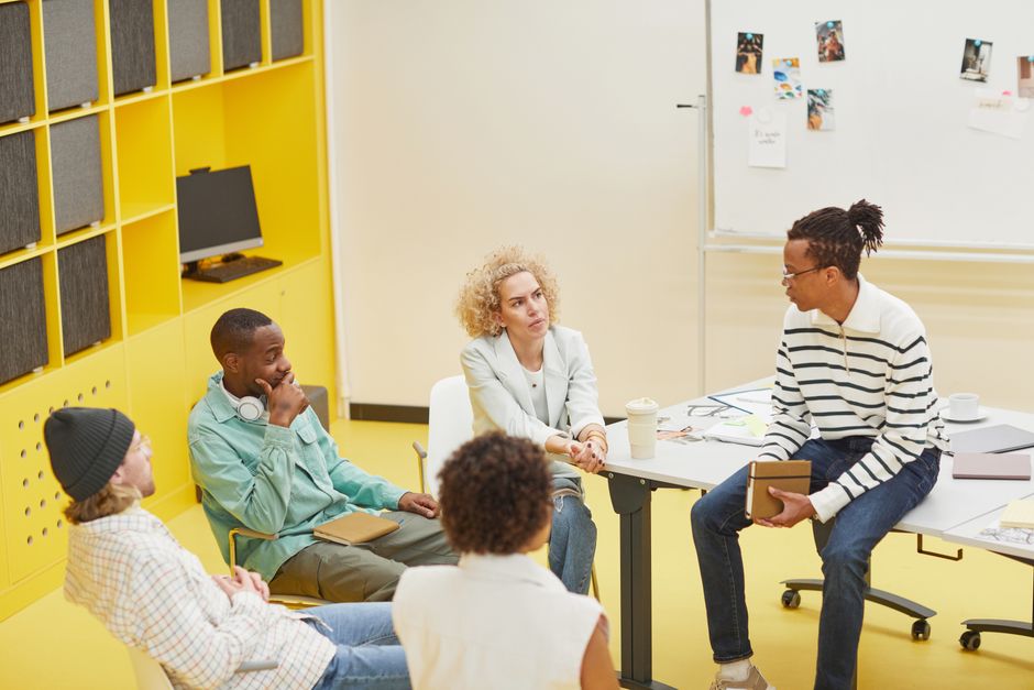 A diverse group engaged in a creative brainstorming session in a modern office setting.