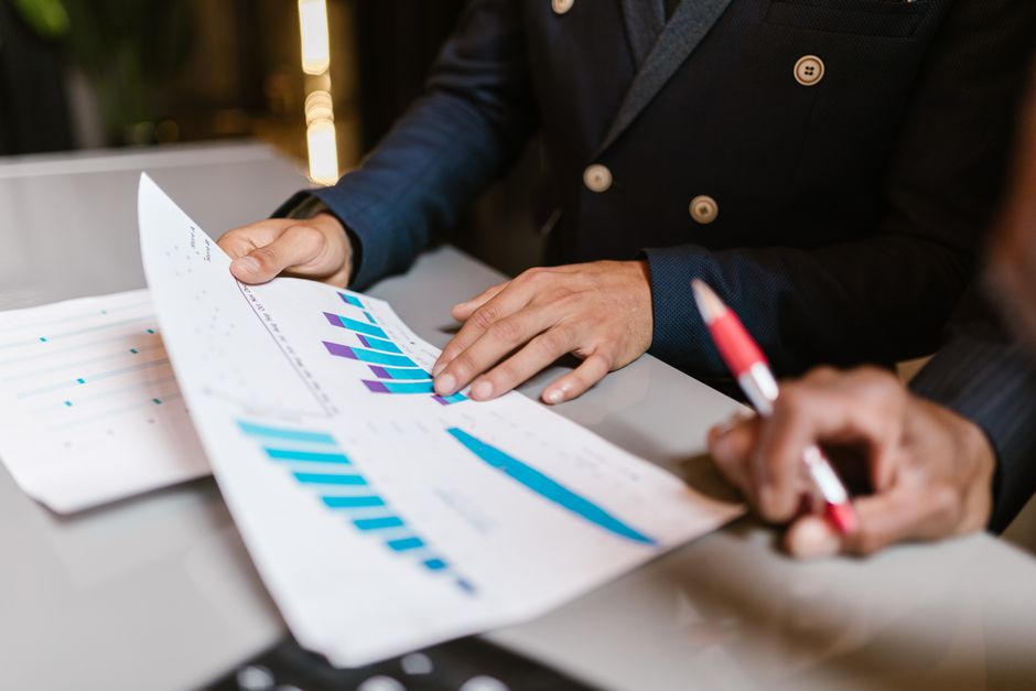 Close-up of professionals reviewing financial graphs at a business meeting.