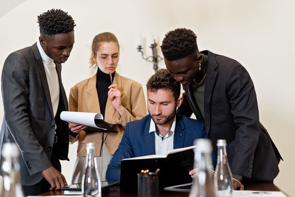 A diverse team of professionals collaborating around a table in a modern office setting.